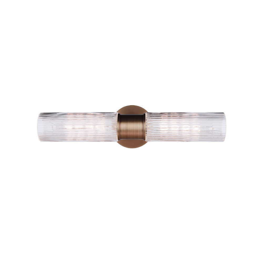 Modern vanity light with double-ended clear ribbed glass cylinders and a antique brass finish wall mount for modern bathroom lighting.