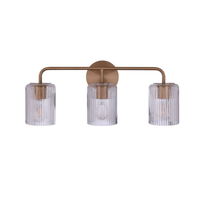 Modern 3-light bathroom vanity light with an antique brass finish metal frame and three clear ribbed glass shades for contemporary bathroom lighting.