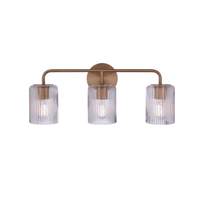 Modern 3-light bathroom vanity light with an antique brass finish metal frame and three clear ribbed glass shades for contemporary bathroom lighting.