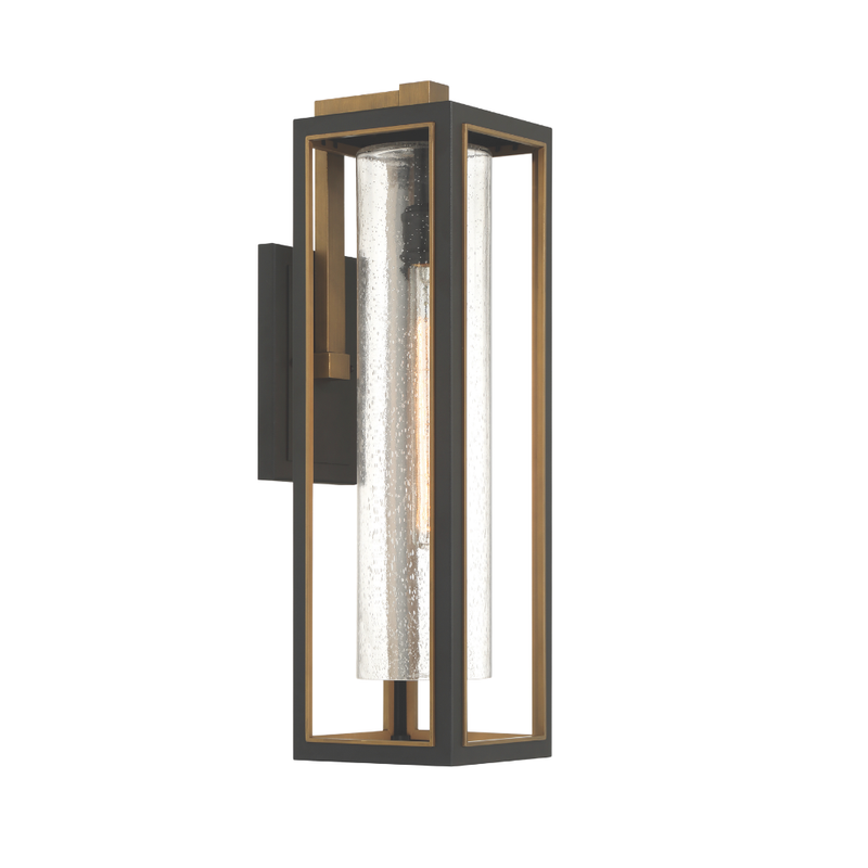 Modern outdoor wall lantern with black frame, brass accents, and seeded glass cylinder shade