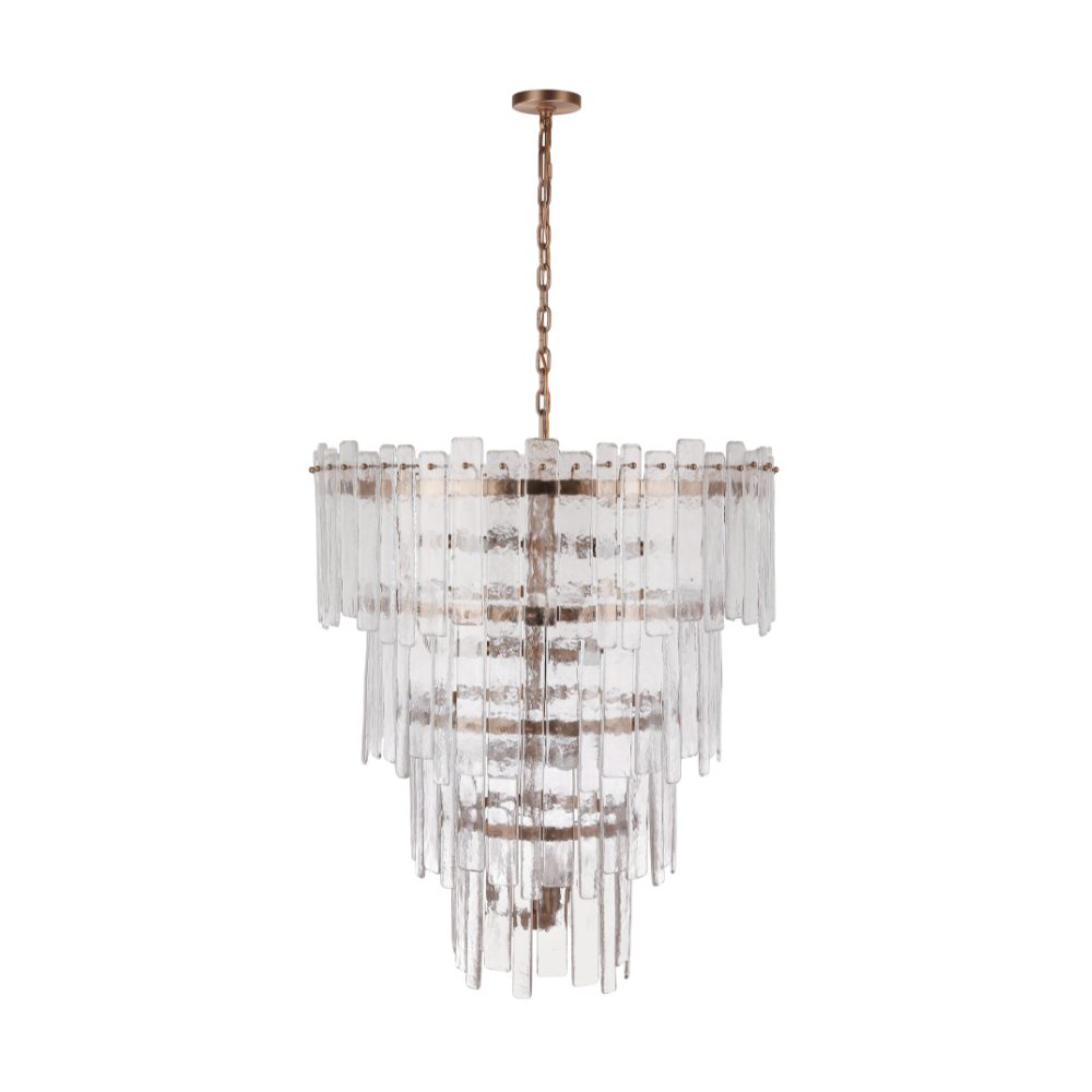 Tiered chandelier featuring textured clear ice glass panels suspended from an aged brass frame and chain